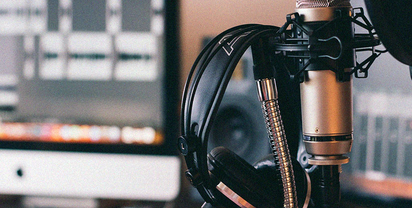Podcasting equipment. A pair of headphones hanging on a studio microphone. | Readable, the ultimate readability tool for proofreading and writing