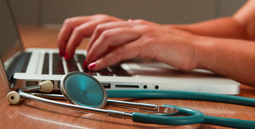 Blog header | Hands typing on a laptop, stethoscope in foreground
