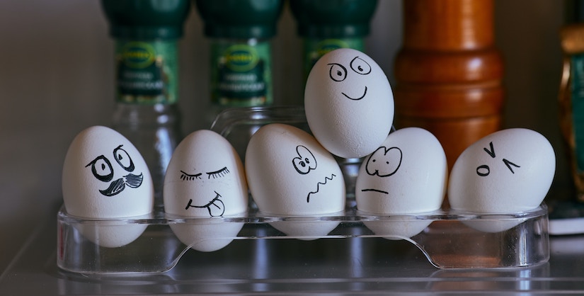 photo of eggs with expressions drawn on them, persuasive language, readability blog
