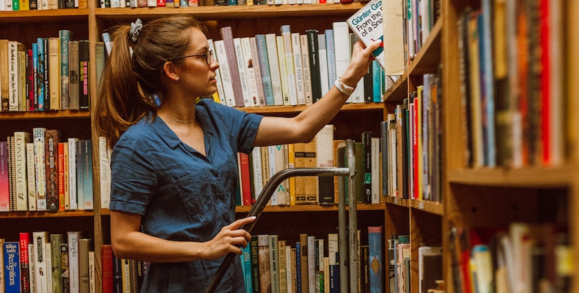 Photo of librarian putting books back on the shelves