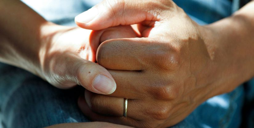 Two people holding hands in a crew setting